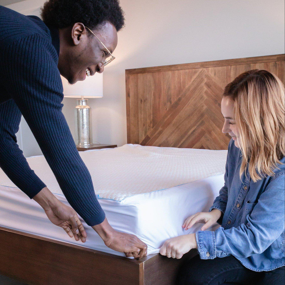 man and woman covering the edge of a Bedface Silver Mattress protector over the corner of Haven Mattress
