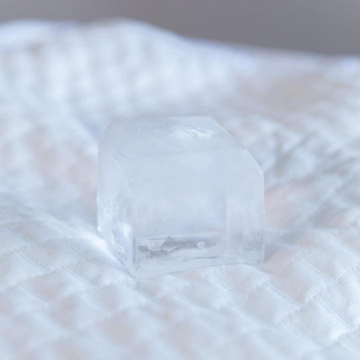 close up of a cube of ice sitting on top of bedface artic cooling pillow protector