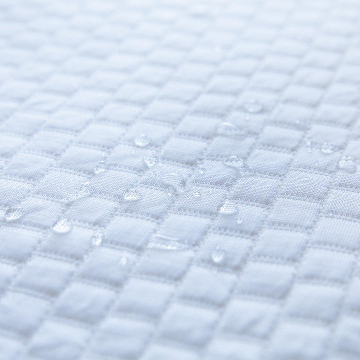 close up of water droplets on top of a Bedface Artic Cooling Mattress protector showcasing that it is waterproof