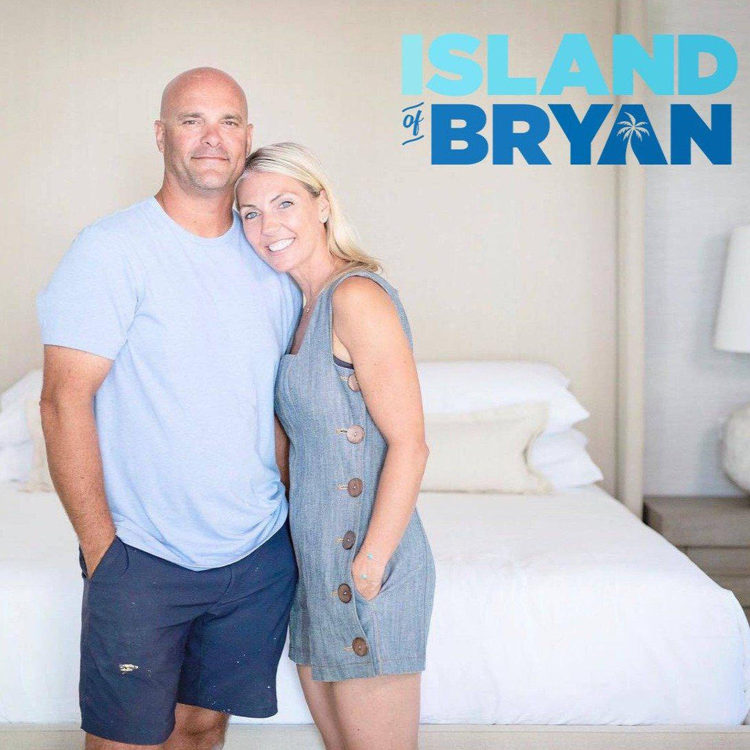 Sarah and Bryan Baeulmer of Island of Bryan HGTV show standing in fron tof a Haven bed-in-box mattress with white bedface sheets and white duvet cover with show logo in top right corner