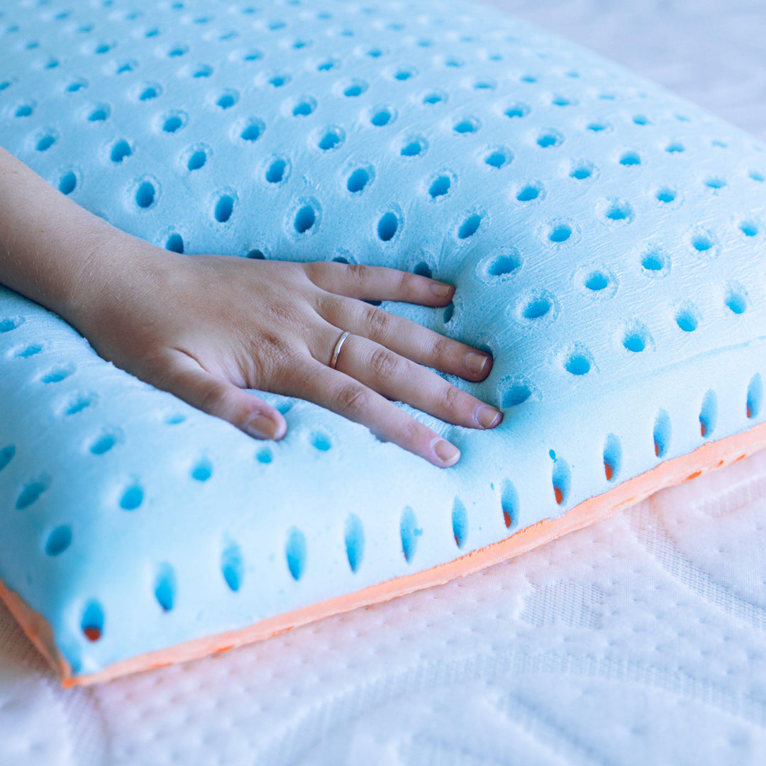 Hand pushing down on a Bedface VitaGel Pillow to sho how the memory foam forms around the hand 