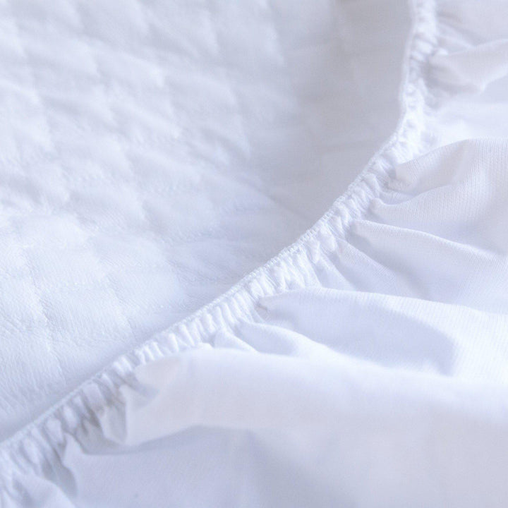 close up of Haven Mattress pillow top showcasing the edges of a Waterproof Protector 